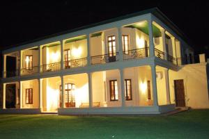 a large white house at night with its lights on at Casco histórico de Estancia in Monte Buey