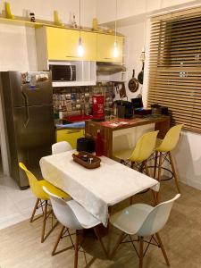 a kitchen with a table and chairs and a refrigerator at Daniel Cozy Flat Copa 1 - à 5min da praia in Rio de Janeiro