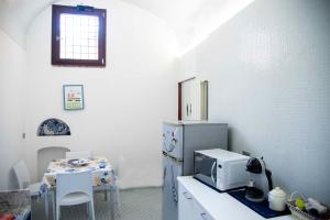 a kitchen with a table with a microwave and a refrigerator at Casa Blu in Vietri