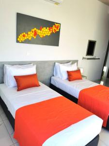 - 2 lits dans une chambre avec des tons orange et blanc dans l'établissement Villa Spilies, à Peyia