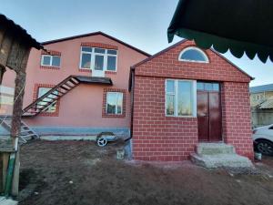 a red brick house with a wooden door at Moreni Guest House in Gavarr