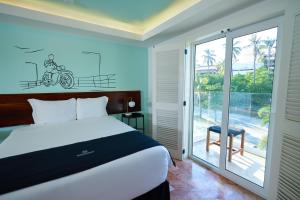a bedroom with a bed and a window with a bike on the wall at The Xperience by g & Beach Club in Mazatlán +61 photos