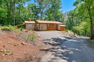 a cabin in the woods with a gravel road at Near Main Street with Hot Tub Retreat in Hiawassee! in Hiawassee