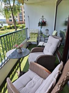 d'un balcon avec des chaises en osier et une table sur une terrasse couverte. dans l'établissement Rheinblick Apartment Remagen, à Remagen