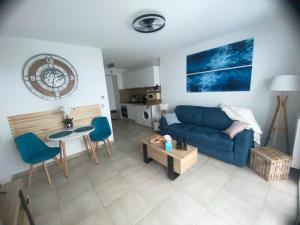 a living room with a blue couch and a table at Chez Candie in La Trinité