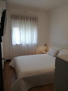 Schlafzimmer mit einem großen weißen Bett und einem Fenster in der Unterkunft Buddies Charm House in Aveiro