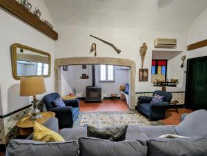 ein Wohnzimmer mit einem Sofa, Stühlen und einem Kamin in der Unterkunft Hotel Solar de Monfalim in Évora