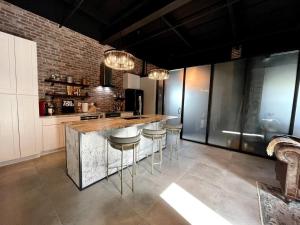 a kitchen with a counter and bar with stools at Luxury Loft - Downtown Tampa, Ybor, Armature in Tampa