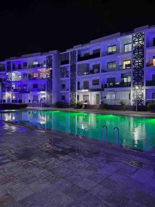 Un gran edificio con piscina por la noche. en Les perles de mimosa Mohammédia, en Mohammedia