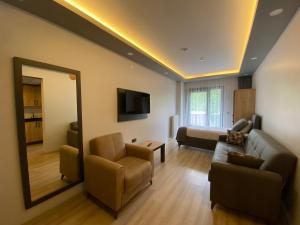 a living room with a couch and a mirror at OF UZUNGÖL APART OTEL in Of