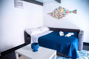 1 dormitorio con 1 cama con manta azul y mesa en Casa Blu, en Vietri