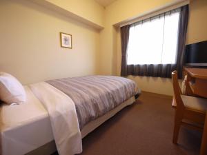 Hotel Route-Inn Shinjyo Ekimae tesisinde bir odada yatak veya yataklar