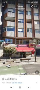 een gebouw met een rode luifel ervoor bij Acogedor apartamento en Vigo in Vigo