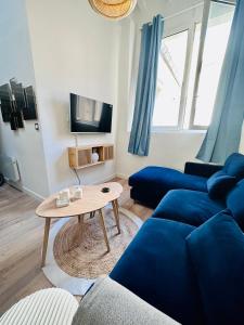 a living room with a blue couch and a table at L'Etoile - Duplex cosy de 50m2 en centre-ville in Nîmes