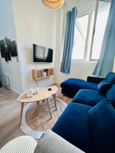 a living room with a blue couch and a table at L'Etoile - Duplex cosy de 50m2 en centre-ville in Nîmes +38 photos