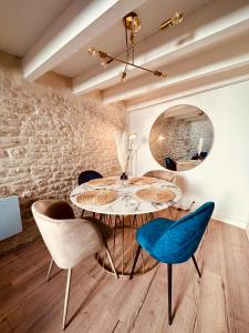 a dining room with a round table and chairs at L'Etoile - Duplex cosy de 50m2 en centre-ville in Nîmes