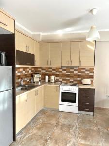 a kitchen with wooden cabinets and a white stove top oven at Anesis home in Gythio