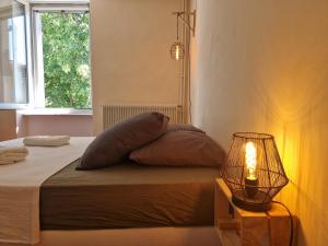 a bedroom with a bed with a lamp and a window at Les Berges de l'Aude in Puicheric