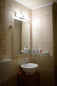 y baño con lavabo y espejo. en Traditional Stone Mezonete en Krousón