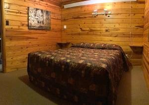 a bedroom with a bed in a log cabin at Trailshead Lodge - Cabin 5 in Lead