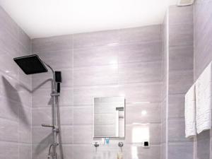uma casa de banho com um chuveiro e um espelho. em Hotel Caucasus Borjomi em Borjomi