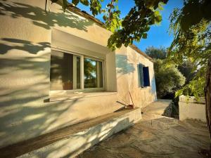 a window on the side of a white house at Two Bedroom 2 Bathroom House in Fanari