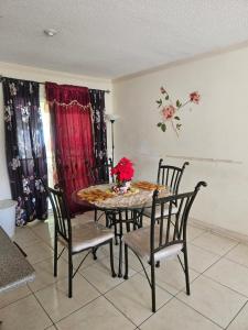 a dining room table and chairs with flowers on it at JA-Spain Retreat in Spanish Town