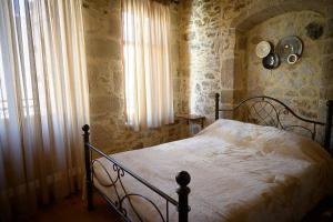 1 dormitorio con 1 cama en una habitación con paredes de piedra en Traditional Stone Mezonete, en Krousón