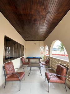 uma sala de estar com mesa de pingue-pongue e cadeiras em Exclusive Holiday Villa with Pool in Accra em Acra