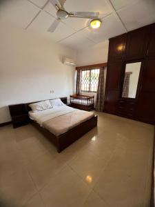 a bedroom with a bed and a ceiling fan at Exclusive Holiday Villa with Pool in Accra in Accra