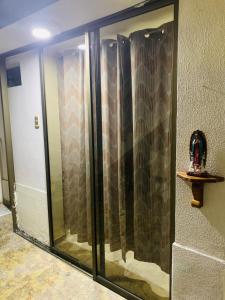 a glass shower in a room with a wall at Casa Merce in Pereira