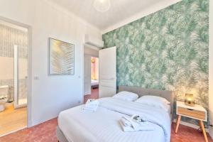een slaapkamer met 2 bedden en een groene muur bij Maison Sara Juan les Pins in Juan-les-Pins