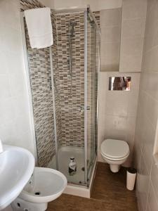 a bathroom with a shower and a toilet and a sink at Hotel Souvenir in Ercolano