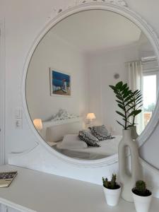 Habitación blanca con cama y espejo en Sea and Salt Naxos 1, en Kastraki Naxou