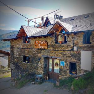 un edificio de piedra con un cartel. en Lo Paller de Roc, en Montescladó