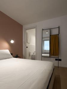 1 dormitorio con 1 cama blanca grande y baño en GARIBALDI13, en Morbegno