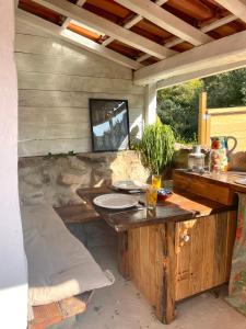 a patio with a wooden table with plates on it at Nativo Natureza Pink Wood Cabin in Cela