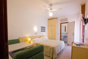 Habitación de hotel con cama y sofá en Hotel Desiree, en Lignano Sabbiadoro
