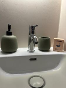 a sink with two green cups and a faucet at Le Madeleine - Cosy & Rénové - Face Tram in Orléans