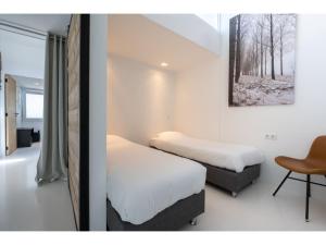 ein Zimmer mit 2 Betten und einem Stuhl darin in der Unterkunft Modern Holiday Home in Kamperland near the Sea in Kamperland