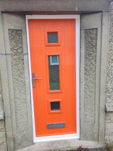 an orange door with two windows on a building at Peaceful Bournemouth Family Retreat in Bournemouth