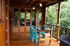 a wooden table and chairs on a porch at Mindo - La Maga in Quito