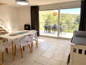 a living room with a table and chairs and a balcony at Aire de las Sierras in Embalse