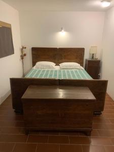 a bedroom with a large bed with a wooden headboard at Villa Venezia in Torre di Mosto