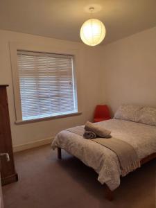 a bedroom with a bed and a large window at Peaceful Bournemouth Family Retreat in Bournemouth