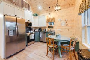 a kitchen with a table and chairs and a refrigerator at Serene Kentucky Cabin with Fireplace and Fire Pit! in Williamstown