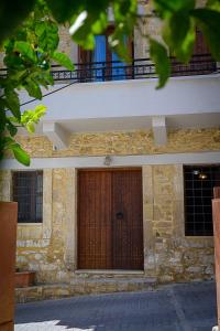 a brick building with a wooden door and a balcony at Traditional Stone Mezonete in Krousón