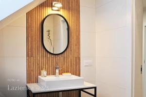 baño con lavabo y espejo en la pared en Mazury Haus en Ruciane-Nida
