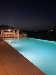 ein Pool mit blauer Beleuchtung in der Nacht in der Unterkunft Lamacesare in Cisternino