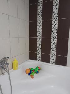 Una bañera blanca con un juguete. en Családi szálláshely a Pilisben, en Piliscsév